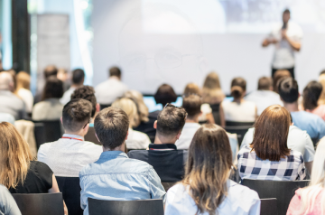 Участники курсов слушают лектора на сцене